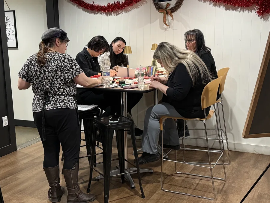 A small group making crafts around a high table