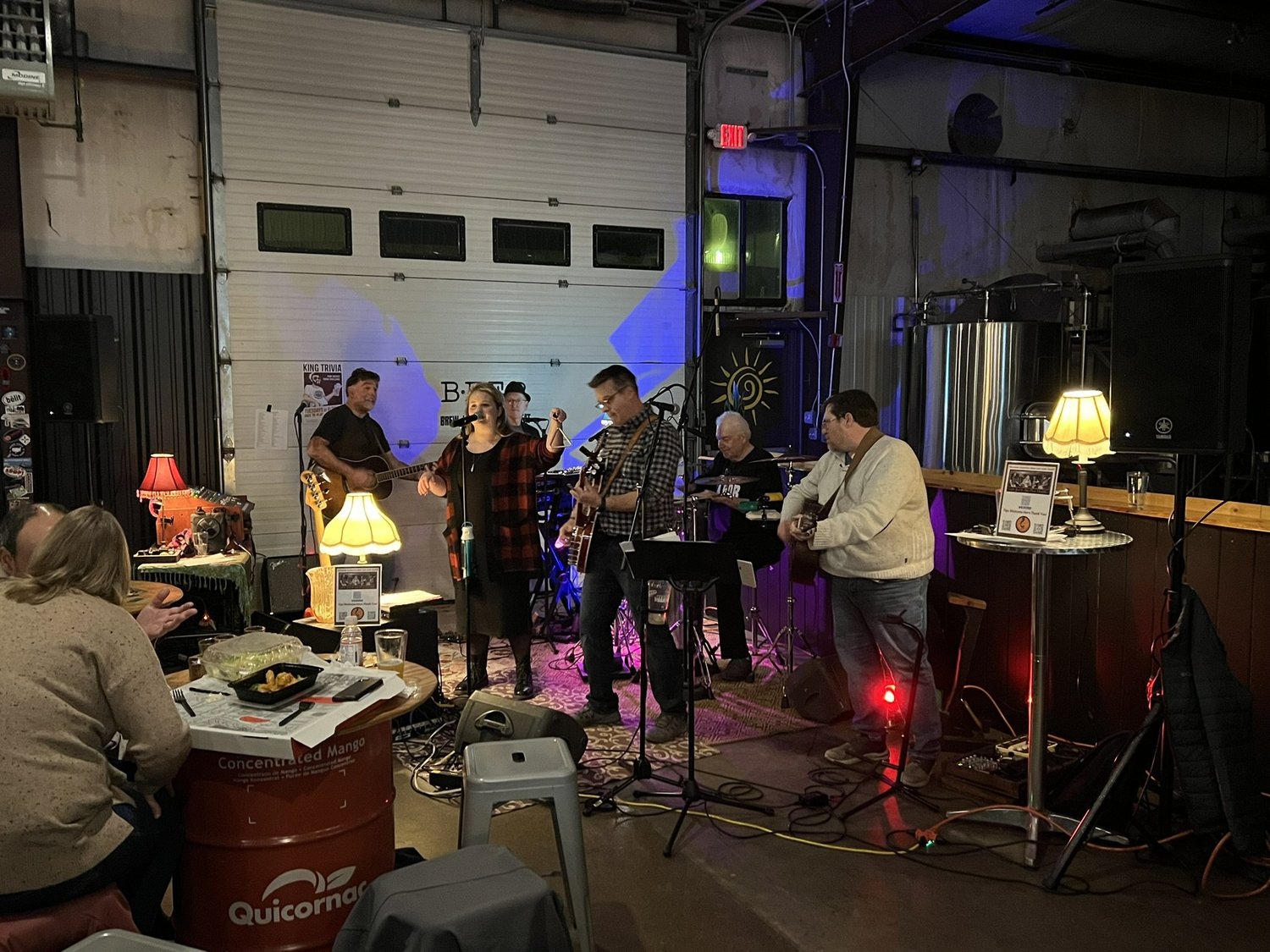 Musicians singing and playing guitars in the CraftRoots taproom