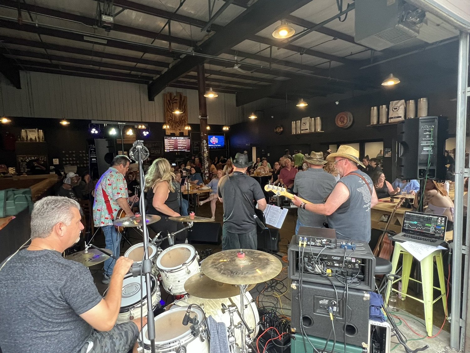 A view from behind the drummer toward the band and taproom audience